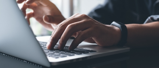 a person typing on a laptop keyboard