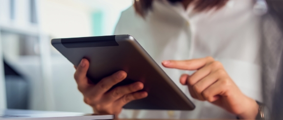 a person tapping a tablet screen