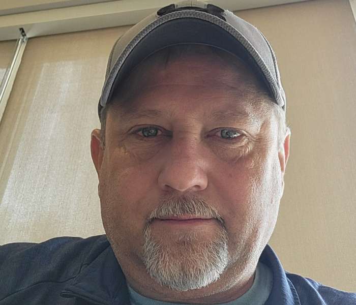 portrait of Steve Bakalar in a cap looking toward the camara